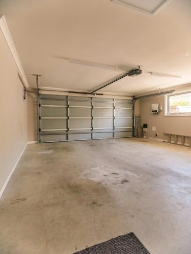 an empty garage with metal garage doors and a window at Coastal Bliss Retreat Elegant Beachside Escape at Hawley Beach in Port Sorell