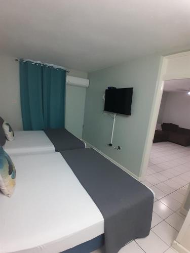 a room with two beds and a flat screen tv at beach 1 bedroom 23 in Ocho Rios
