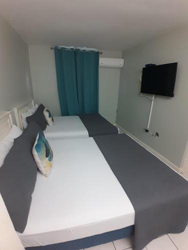 a bedroom with a large white bed with a television at beach 1 bedroom 23 in Ocho Rios