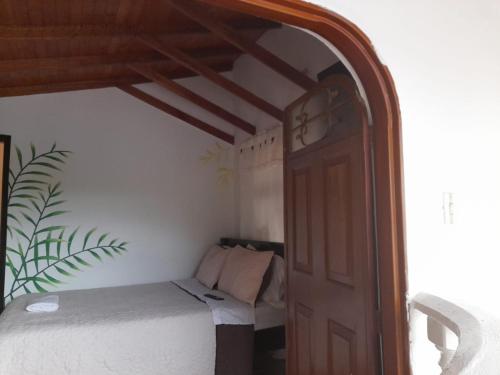 a bedroom with a bed and an open door at La Cabaña Eco Hotel in Suaita