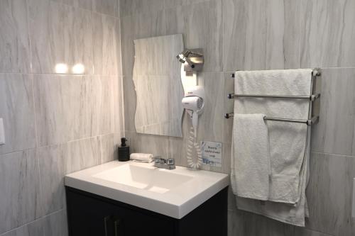 a bathroom with a sink and a mirror and towels at Pino Apartment in Oaxaca City