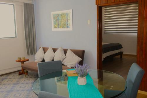 a living room with a glass table and a couch at Pino Apartment in Oaxaca City