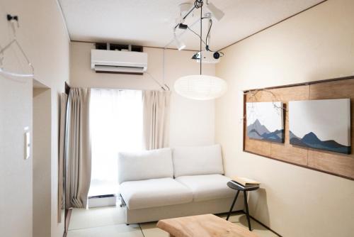 a living room with a white couch and a window at Saku House Jujo in Tokyo