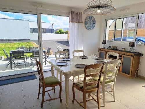une salle à manger avec une table et des chaises et une grande fenêtre dans l'établissement Holiday Home in Brittany near Roscoff Harbor, à Cléder