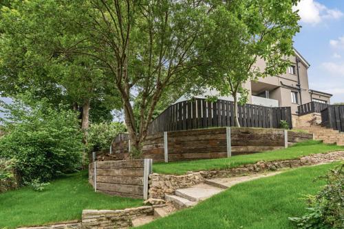 a fence in front of a house with green grass at The Ridge London - Luxury Designer Villa with hot tub and sauna, Bexley borough of London in London