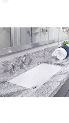 a bathroom counter with a sink and a mirror at Cozy Roseville Home in Roseville