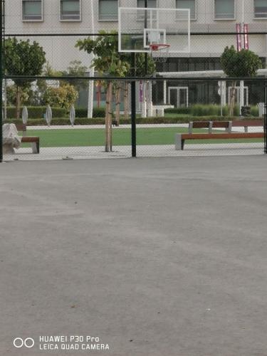 a basketball court with two benches and a basketball hoop at Jupiter Saadiyat Beach New York Abu Dhabi university Studio Apartment in Abu Dhabi