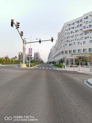 an empty street with traffic lights and a building at Jupiter Saadiyat Beach New York Abu Dhabi university Studio Apartment in Abu Dhabi