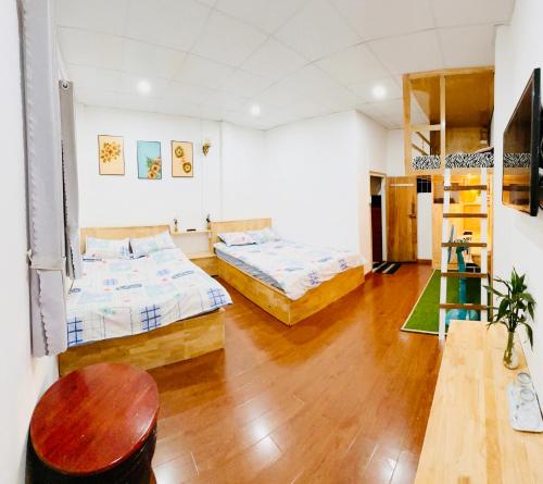 a large room with two beds and a table at Suri's House Homestay in Da Lat