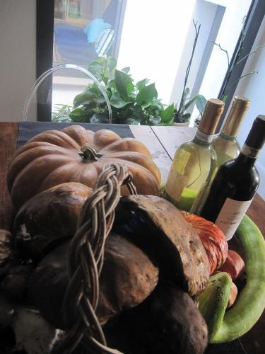 a basket of vegetables and wine bottles on a table at Brancadoria B&B in Monteleone Rocca Doria