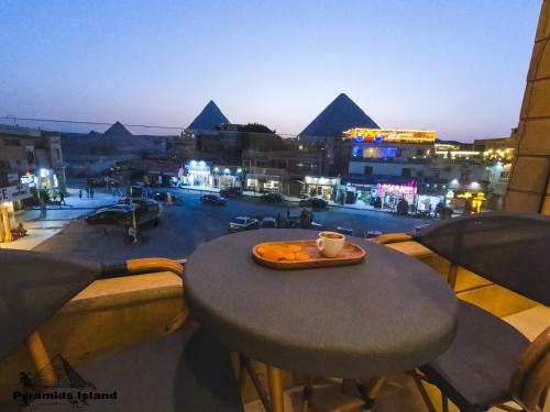 a table with a cup of coffee on top of a balcony at Pyramids Island in Cairo
