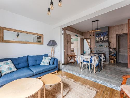 un salon avec un canapé bleu et une table dans l'établissement Maison avec jardin clos, proche océan et centre, WIFI, 7 pers, clim, plancha, non-fumeur - FR-1-521-101, à Biscarrosse-Plage