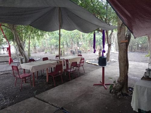 a group of tables and chairs under an umbrella at SECLUDED GLAMPING YOGA SAMADHI fan 2 kubos 8 pax in Rimus