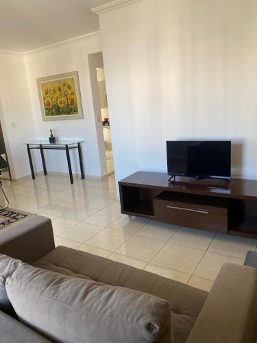 a living room with a couch and a flat screen tv at Moderno, equipado e no melhor bairro - Aquarius I in São José dos Campos