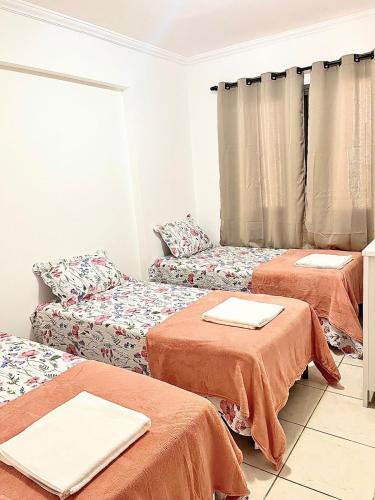a room with two beds and a couch at Moderno, equipado e no melhor bairro - Aquarius I in São José dos Campos
