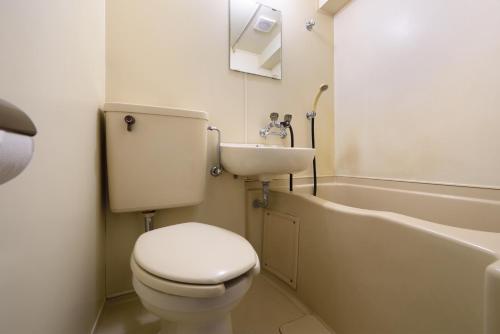 Un baño con inodoro, lavabo y bañera. en Hotel Park Sendai 2, en Sendai