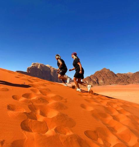 two people riding on bikes in the desert at Wadi Rum Luxure desert Camp in Wadi Rum
