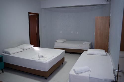 a small room with two beds and twounks at Hotel Home in Lucas do Rio Verde