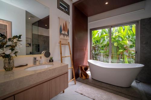 a bathroom with a large tub and a window at Villa Anastasia Aonang in Ao Nang 