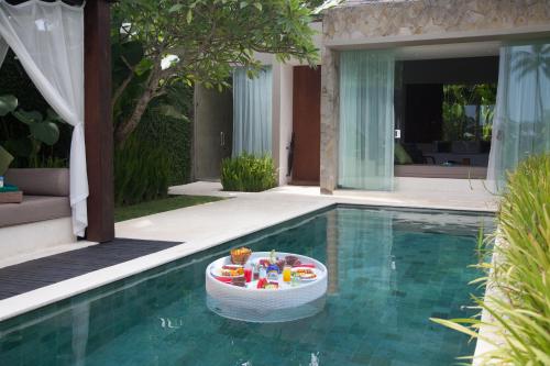 a pool with a toy table in the middle of it at Candi Beach Resort & Spa in Candidasa