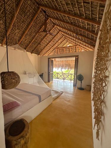 a bedroom with a bed and a large window at Cabañas Mizontle in Mazunte