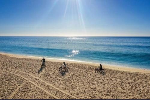 trois personnes font du vélo sur la plage dans l'établissement Ocean view suite, à El Bedito