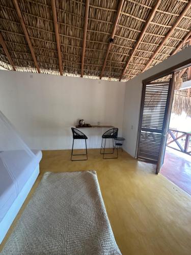 a room with a table and two chairs in it at Cabañas Mizontle in Mazunte
