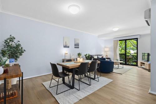 a dining room and living room with a table and chairs at Exclusive Northbridge Apt w Wi-Fi Pool in Perth