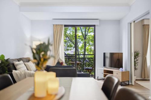 a living room with a couch and a television at Exclusive Northbridge Apt w Wi-Fi Pool in Perth