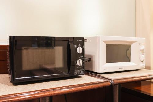 a microwave and a microwave oven sitting on a counter at Hotel Sunroute Niigata in Niigata