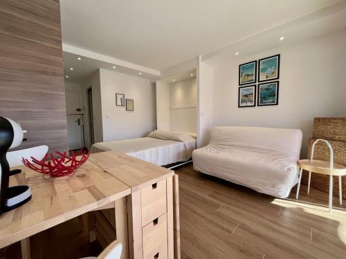 une chambre avec deux lits et un bureau dans l'établissement Studio rénové 4 pers à Cavalaire-sur-Mer avec balcon et parking - FR-1-226B-190, à Cavalaire-sur-Mer