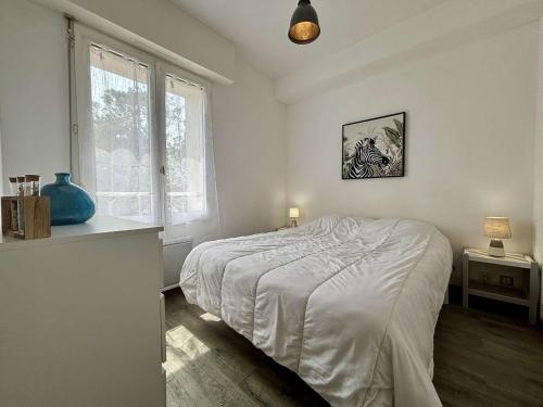 a white bedroom with a bed and a window at Appartement rénové 3 pièces, vue mer, 4 couchages, Wifi, St-Trojan-les-Bains - FR-1-246A-315 in Saint-Trojan-les-Bains