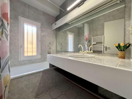a bathroom with a sink and a tub and a mirror at Appartement rénové 3 pièces, vue mer, 4 couchages, Wifi, St-Trojan-les-Bains - FR-1-246A-315 in Saint-Trojan-les-Bains