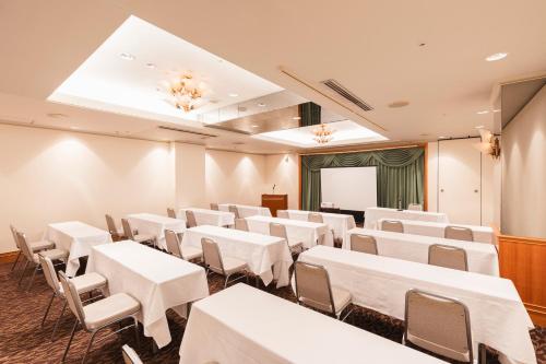 a conference room with white tables and chairs at Hotel Sunroute Niigata in Niigata