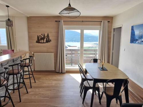 une salle à manger avec une table et des chaises et une fenêtre dans l'établissement Bel Appartement 4 pièces rénové, 3 chambres, 2 terrasses, parking, cuisine équipée, Les Angles - FR-1-593-112, aux Angles