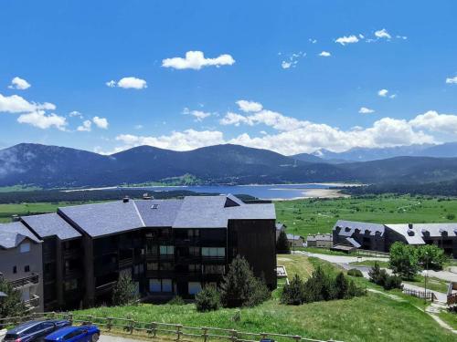 - un bâtiment avec vue sur le lac et les montagnes dans l'établissement Bel Appartement 4 pièces rénové, 3 chambres, 2 terrasses, parking, cuisine équipée, Les Angles - FR-1-593-112, aux Angles