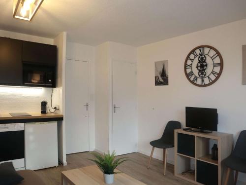un salon avec une horloge au mur dans l'établissement Studio rénové, calme, skis aux pieds, 6 pers, Les Orres - FR-1-322-630, aux Orres