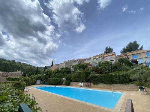 une piscine devant un immeuble dans l'établissement Appartement avec piscine et parking à Cavalaire-sur-Mer - FR-1-100-341, à Cavalaire-sur-Mer