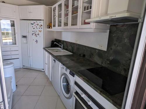 une cuisine avec un évier et une cuisinière four supérieur dans l'établissement T4 spacieux avec terrasse et vue panoramique, parking inclus - FR-1-250-286, à La Grande Motte