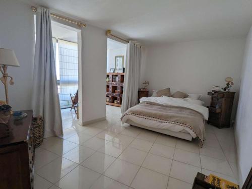 une chambre blanche avec un lit et une grande fenêtre dans l'établissement T4 spacieux avec terrasse et vue panoramique, parking inclus - FR-1-250-286, à La Grande Motte