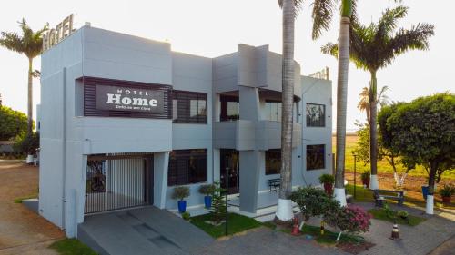 a white building with a sign for a hotel at Hotel Home in Lucas do Rio Verde