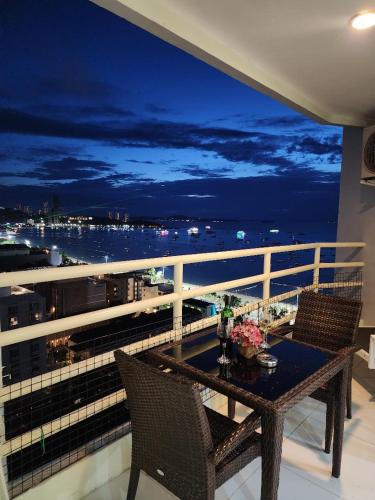 a table on a balcony with a view of the ocean at View Talay6 Mark Apartments in Pattaya