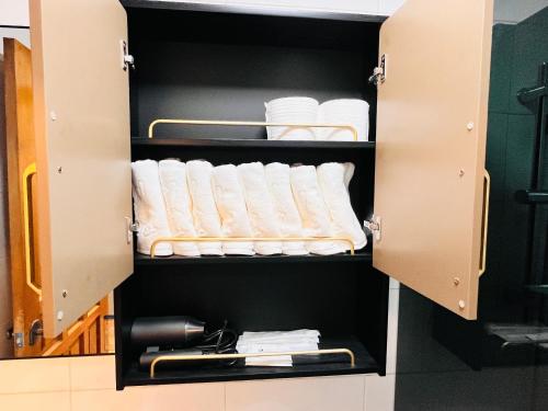 a cupboard with white towels and a rack of towels at Gyeongju MaMa in Gyeongju