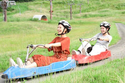 two young girls riding on a ride on a roller coaster at New Greenpia Tsunan in Tsunan