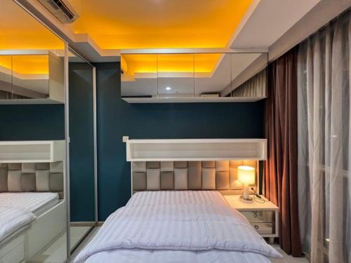 a bedroom with a bed and a blue wall at 2 Bed Casa Grande Mall Kota Kasablanka By Travelibu in Jakarta