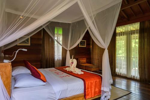 a bedroom with a bed with a canopy at Pertiwi Bisma 1 in Ubud