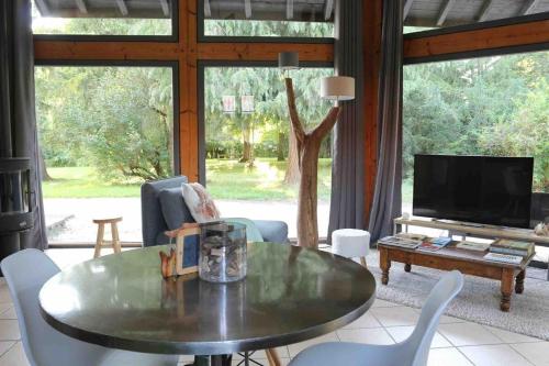 un salon avec une table et une télévision dans l'établissement le nid des écureuils-gitesdanslain, à Pont-dʼAin