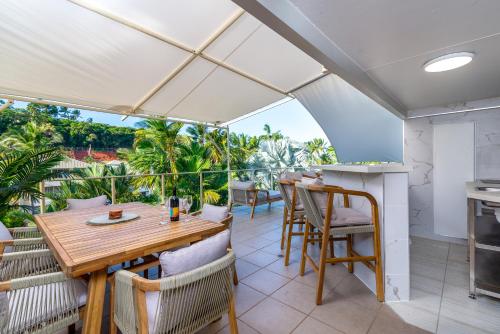a dining room with a table and chairs on a balcony at Driftwood Mantaray - Official Onsite Reception and Check In in Port Douglas