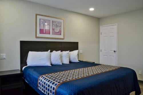a bedroom with a bed with blue sheets and white pillows at The Maverick Motel, Main Street USA Collection by PNW Hospitality in Klamath Falls
