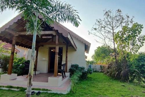 una casa con una palmera delante en FarmStay FamilyVilla Vadodara, en Vadodara